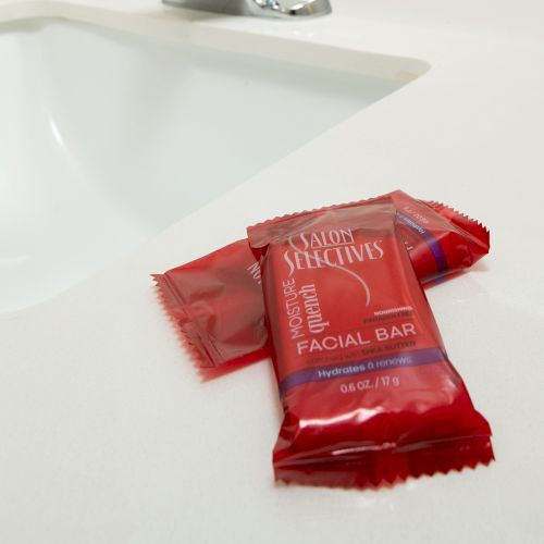 Red-packaged facial bars are placed near a white sink on a countertop.