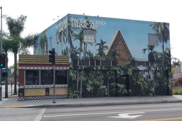 A building features a mural with palm trees and a Pacific island theme, labeled 